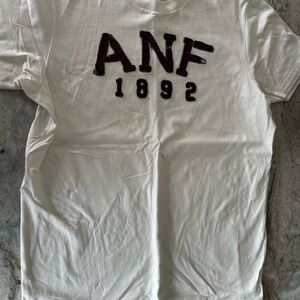 Abercrombie & Fitch Cream Crewneck Tee with appliquéd letters muscle fit.